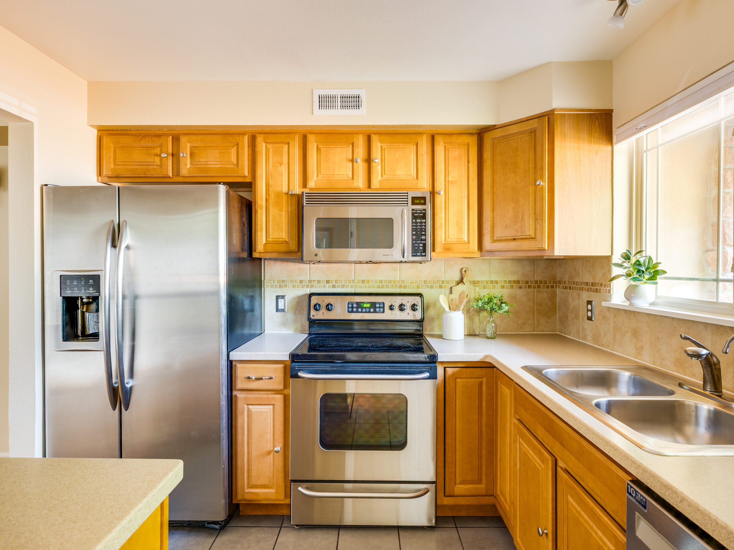 Stainless steel kitchen with light wood cabinetry and natural light at 4800 Osage Dr Unit 12B
